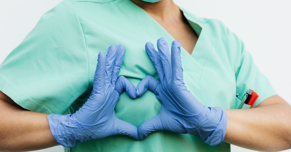 Medical professional forming a heart shape with blue gloves. Symbol of care and compassion.
