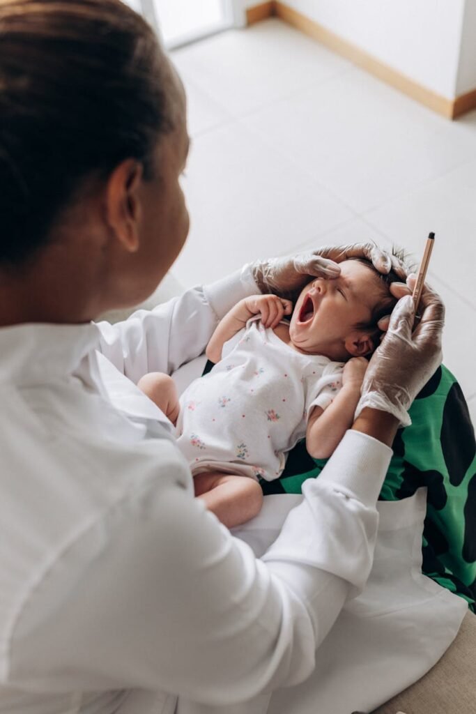 a woman is holding a baby s head while another person is holding a syringe
